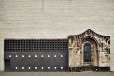 an old building with holes on the side and a large door in front of it