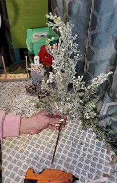 a person is making a flower arrangement on a table