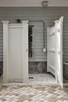 an open door leading into a bathroom next to a brick floor