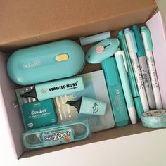 an open box with pens, markers and other items