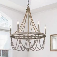 a chandelier hanging from the ceiling in a room with white walls and windows