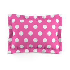 a pink pillow with white polka dots on it