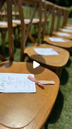 a row of wooden chairs with paper on top of them and writing on the back