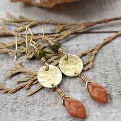 You can almost smell the crisp fall air with these boho autumn earrings. dainty brass disc's are hammered to perfection and adorned with rich green Czech glass and pumpkin orange fall leaves. Finished with 14k gold plated earring hooks. - Gorgeous boho autumn styling - Brass materials - Czech glass beads - 14k gold plated earring hooks with rubber backs included True Autumn Jewelry, Bohemian Leaf-shaped Brass Jewelry, Bohemian Brass Leaf Jewelry, Earthy Brass Dangle Earrings, Rustic Brass Drop Earrings, Rustic Brass Dangle Earrings, Nickel-free Brass Earthy Earrings, Earthy Nickel-free Brass Earrings, Earthy Brass Jewelry With Ear Wire