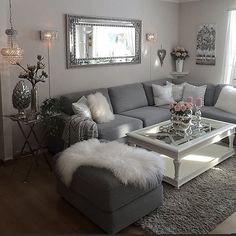 a living room filled with lots of furniture next to a large mirror on the wall