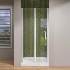 a bathroom with a corner shower stall and wooden flooring in front of a window