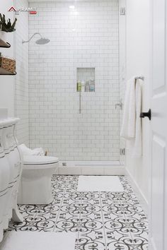 a white bathroom with black and white floor tiles