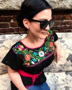 These stunning, vibrant Mexican blouses are meticulously handcrafted by skilled artisans in Oaxaca, a state steeped in rich tradition. With their short sleeves, chic o-neckline, and exquisite mix of medium and  petite floral motifs, these blouses exude effortless coolness. Each blouse is made from a blend of fresh Mexican cotton, adorned with captivating embroidery in a kaleidoscope of colors. Whether you're going about your daily routine, attending work, enjoying a shopping spree, or lounging b Fitted Short Sleeve Top With Embroidered Hem, Fitted Short Sleeve Embroidered Top, Traditional Embroidered Short Sleeve Top For Festive Occasions, Traditional Embroidered Crew Neck Top For Spring, Traditional Embroidered Fitted Top With Short Sleeves, Traditional Crew Neck Embroidered Top For Spring, Fitted Embroidered Short Sleeve Top, Fitted Embroidered Top With Short Sleeves, Traditional Short Sleeve Blouse With Floral Embroidery