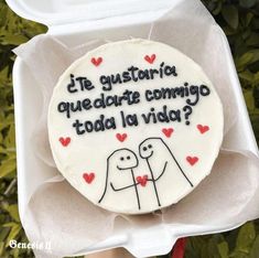 a decorated cookie in a box that says,'i gusteria queadre commo tod la viada? '