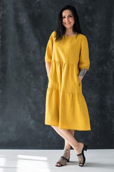 "This swingy tiered dress is tailored from soft washed medium weight linen and designed with a relaxed round neckline and wide sleeves. A feminine effortless silhouette for spring/summer comfort and ease.   Details Tiered silhouette with gathered seams   Collarless neckline  Side seam pockets Mid-length puff sleeves  Below the knee length Hem slightly longer at the back Button closure at the back 100% washed Lithuanian linen.  Machine wash 30 C.   SIZE CHART:  XS-4 US/ 6UK/ 36 EU: Bust 33\" (84 cm) , Waist 25\" (63,5 cm), Hips 36\" (92 cm)  S-6 US/ 8UK/ 38 EU: Bust 35\" (88 cm) , Waist 26,5\" (67,5 cm), Hips 38\" (96 cm) M-8 US/ 10UK/ 40 EU: Bust 36\" (92 cm), Waist 28\" (72 cm), Hips 39\"(100 cm) L-10 US/ 12UK/ 42 EU: Bust 38,4 \" (96 cm) , Waist 30,4\" (76 cm), Hips 41,6\" (104 cm) XL-12 Summer Linen Tiered Dress, Yellow Casual Linen Dress For Spring, Linen Tiered Dress For Daywear, Spring Tiered Linen Midi Dress, Yellow Linen Dress For Spring, Yellow Linen Dress, Dress Rich, Tier Dress, Girls In Mini Skirts