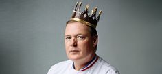 a man with a crown on his head wearing a baseball uniform and looking at the camera