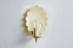 a light that is on the wall with a bulb in it's center and an object behind it