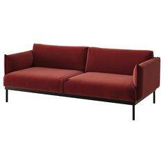 a red couch sitting on top of a white floor next to a black metal frame