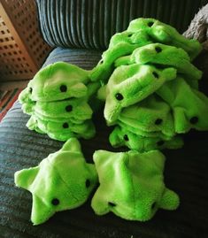 several green stuffed animals sitting on top of a couch