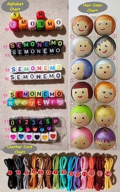 there are many different colored beads on the table and in front of them is an assortment of smiling faces