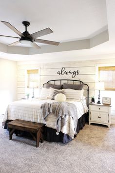 a bedroom with a bed, nightstands and ceiling fan in the middle of it