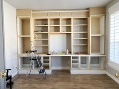 an empty room with shelves and ladders in it