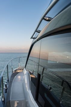 the back end of a boat traveling on the ocean at sunset or sunrise, looking out over the water