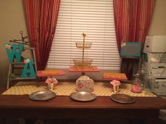 a table topped with plates and cake next to a window