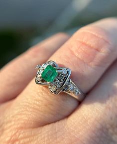 Elevate your jewelry collection with this very unique Vintage Emerald and Diamond Art Deco Style Ring--an exquisite fusion of timeless elegance and Art Deco glamour. This ring is a testament to the opulence of a bygone era, featuring a lush emerald at its center, surrounded by a dazzling array of diamonds, all set in a meticulously crafted Art Deco-inspired design.  Natural emerald weighing .44 carats Natural Diamonds weighing .15 carats.  Size: 6.5 The emerald, with its rich green hue, is a cap Classic Gia Certified Diamond Ring As Collectible, Gia Certified Diamond Rings For Collectors, Gia Certified Platinum Collectible Rings, Exquisite Platinum Emerald Ring With Brilliant Cut, Gia Certified Classic Emerald Ring, Heirloom Gia Certified Diamond Ring, Hallmarked Oval Emerald Ring In Platinum, Oval Hallmarked Emerald Ring In Platinum, Emerald Ring With Center Stone In 14k White Gold