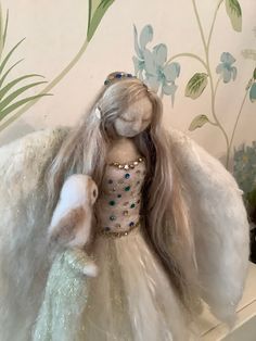 a stuffed animal is sitting on top of a white horse with long hair and blue eyes