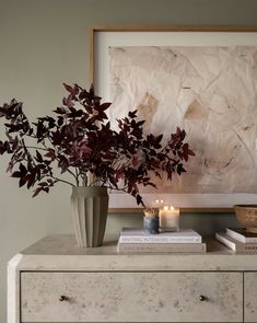 a vase filled with flowers sitting on top of a dresser