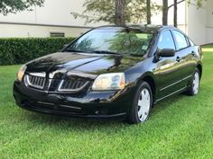 a black car is parked in the grass