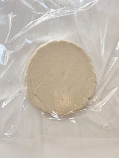 an uncooked tortilla sitting on top of plastic wrapped in cellophane