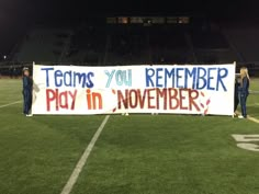 two women holding a sign on the sidelines of a football field that says teams you remember play in november