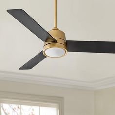 a ceiling fan that is hanging from the ceiling in a room with white walls and windows