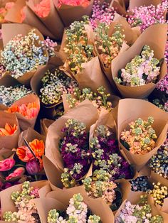 there are many different flowers in brown paper bags