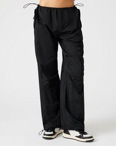 A wide leg casual pant is essential for an updated silhouette and the adjustable PIA parachute pants use stretch cord drawstrings and clever tailoring to maximize the voluminous silhouette. Wide parachute pants Zipper fly closure Two side snap pockets Stretch cord drawstring with toggle closure in waistband and cuffs Length: 30.25" 55% nylon 45% polyester Care instructions: hand wash cold separately, do not bleach, lay flat to dry, low iron if necessary, or dry clean Shop the set here Jelixza is Black Utility Parachute Pants, Black Utility Parachute Pants With Drawstring, Nylon Techwear Pants With Functional Drawstring, Functional Wide Leg Parachute Pants For Outdoor, Functional Wide-leg Parachute Pants For Outdoor, Black Techwear Parachute Pants With Drawstring, Black Parachute Pants With Functional Drawstring For Outdoor, Nylon Wide Leg Cargo Parachute Pants, Nylon Wide Leg Parachute Pants With Cargo Pockets