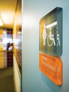 an orange and white sign that says female change room on the side of a blue wall