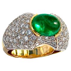 This elegant 18k yellow gold Late-20th century ladies dome ring is set with one rich green natural Colombian emerald double cabochon weighing approximately 3.15ct. Color saturation in this gem is very intense and uniform. GIA report number 2239214304 which states that the emerald is F2*enhanced will be delivered with the ring.Flanking this very well saturated and transparent gem are a total of approximately 86 round brilliant cut diamonds having a total approximate weight of 1.75ct and an overall quality of H color and VS1 clarity. The 18k yellow gold mounting is expertly crafted with sizing spring and comfort grill and, the design area measures 7/8 inches by 1/2 inch, making this beautiful vintage ring impossible to overlook. The emerald rises a full 3/8 inches above the finger. Size is 6 Luxury Domed Green Emerald Ring, Collectible Yellow Gold Emerald Cabochon Ring, Luxury Cabochon Emerald Ring With Diamonds, Unique Luxury Emerald Cabochon Ring, Luxury Collectible Emerald Cabochon Ring, Beautiful Rings Vintage, Dome Ring, Colombian Emeralds, Rich Green