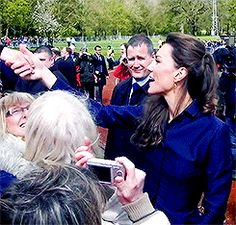 the woman is taking a selfie with her cell phone in front of an audience