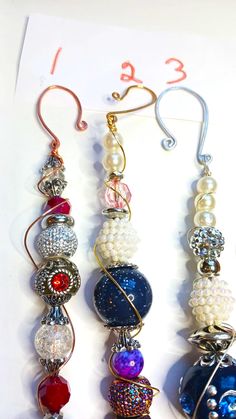 three different types of beaded earrings hanging from hooks