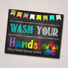 a chalkboard sign that says wash your hands with colorful handprints on it