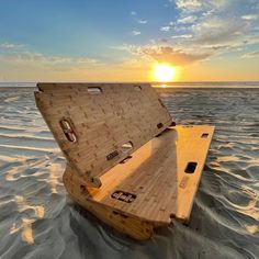 an open wooden box sitting on top of the sand in the middle of the ocean