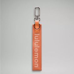 an orange keychain with the word millennium printed on it and a metal hook