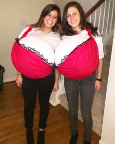 two women standing next to each other with large belly bags on their stomachs in front of them