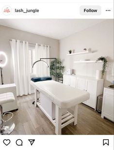 a white table sitting in the middle of a room next to a sink and window