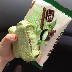 a person holding up a bag of green food in their left hand and the inside of it