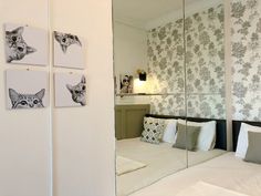 a bed room with a mirror and pictures on the wall