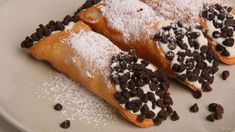 chocolate chip pastries on a plate with powdered sugar and chocolate chips around them