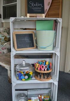 a white shelf filled with lots of crafting supplies on top of a carpeted floor