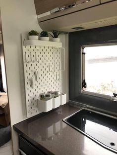 a kitchen area with sink, stove and cabinets in a trailer or camper's home