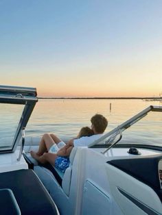 two people sitting on the back of a boat