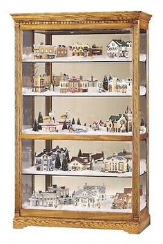 a wooden display case filled with lots of toy houses and trees on top of it