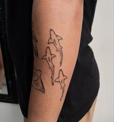 a man with a tattoo on his arm has three shark tattoos on it's arms