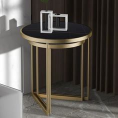 a black and gold side table with a single flower in it's centerpiece